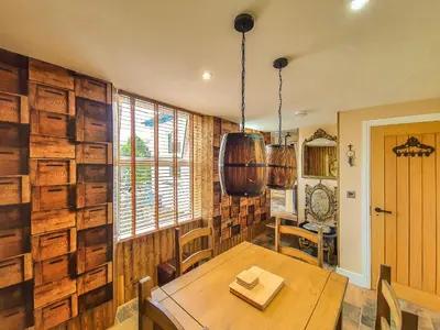 a dining room with wooden walls and a wooden table at Deluxe Pirate's Cove Themed Apartment in St Austell