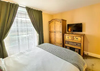 a bedroom with a bed and a tv and a window at Deluxe Pirate's Cove Themed Apartment in St Austell