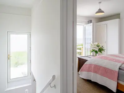 a white bedroom with a bed and a window at Beachside, West Yardley House - Uk31200 in Downderry