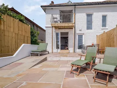 a patio with chairs and a table and a building at Beachside, West Yardley House - Uk31200 in Downderry