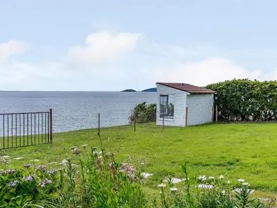 a small house in a field next to the water at Beachside, West Yardley House - Uk31200 in Downderry