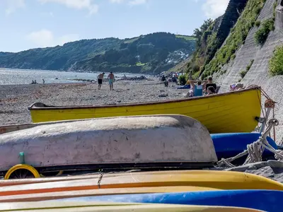 a yellow boat sitting on a beach next to the ocean at Beachside, West Yardley House - Uk31200 in Downderry