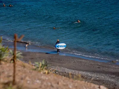 a man walking on the beach with a surfboard at Beachside, West Yardley House - Uk31200 in Downderry