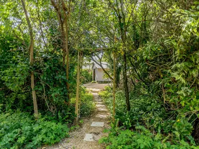 a path through the trees with a house in the background at Beachside, West Yardley House - Uk31200 in Downderry
