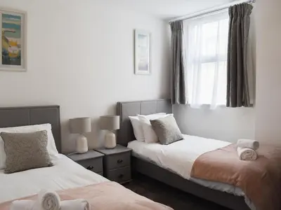 a bedroom with two beds and a window at Beach View in Newquay