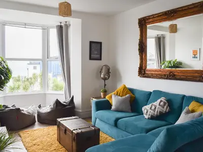 a living room with a blue couch and a mirror at Beach View in Newquay