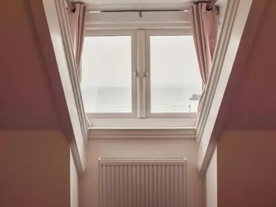 a large window in a room with a radiator at Beach View in Newquay