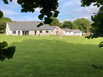 an old stone house on a green field at The Corn Store in St Austell