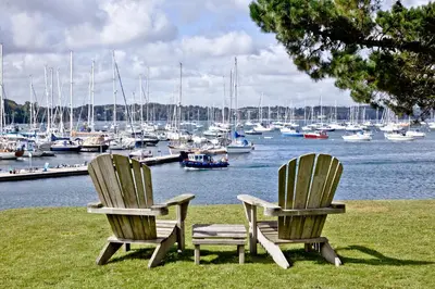 two chairs sitting next to a marina with boats at Cregoes, Mylor - Bungalow - Riverview - Free Parking & WiFi - Pet friendly in Flushing