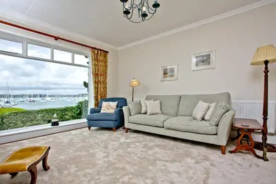 a living room with a couch and a chair and a window at Cregoes, Mylor - Bungalow - Riverview - Free Parking & WiFi - Pet friendly in Flushing