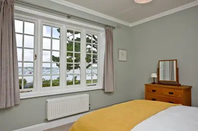 a bedroom with a bed and a large window at Cregoes, Mylor - Bungalow - Riverview - Free Parking & WiFi - Pet friendly in Flushing