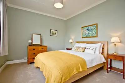 a bedroom with a large bed with a yellow blanket at Cregoes, Mylor - Bungalow - Riverview - Free Parking & WiFi - Pet friendly in Flushing