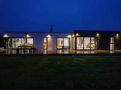 a large house at night with a lawn in front of it at Atlantic View in Penzance