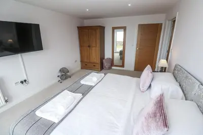 a bedroom with a bed and a flat screen tv at Atlantic View in Penzance