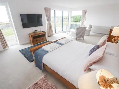 a bedroom with a large bed and a tv at Atlantic View in Penzance