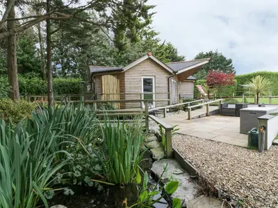 a cabin in a garden with a patio at Brambleside Lodge in Truro