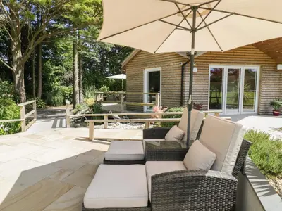 a patio with a couch and an umbrella at Brambleside Lodge in Truro