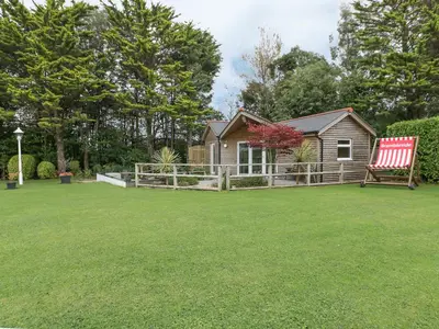 a yard with a house and a red chair at Brambleside Lodge in Truro