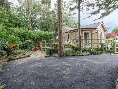 a home with a fence and a house at Brambleside Lodge in Truro