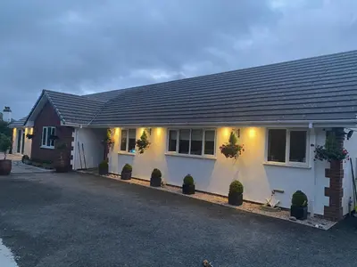 a white house with potted plants in front of it at Toppesfield House B&B in Bude