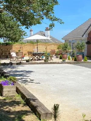 a patio with a table and chairs and an umbrella at Toppesfield House B&B in Bude