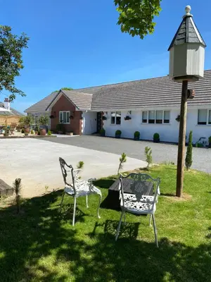 two chairs and a table in front of a building at Toppesfield House B&B in Bude