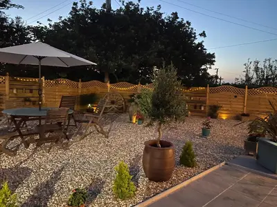 a patio with a table and an umbrella at Toppesfield House B&B in Bude