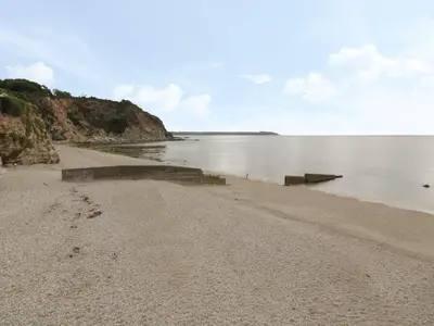 a sandy beach with a view of the water at Lantern Cottage in St Austell