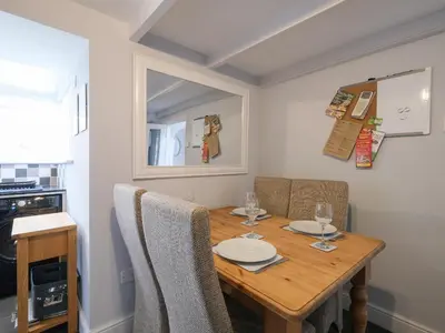 a dining room with a wooden table and chairs at Lantern Cottage in St Austell