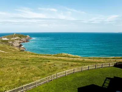 a view of the ocean from a hill with a fence at Breakers in Newquay