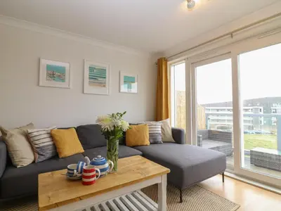 a living room with a couch and a table at Breakers in Newquay