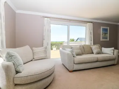 a living room with two couches and a large window at Trevore Farmhouse in Truro