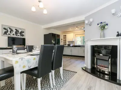 a dining room with a table and a fireplace at Trevore Farmhouse in Truro