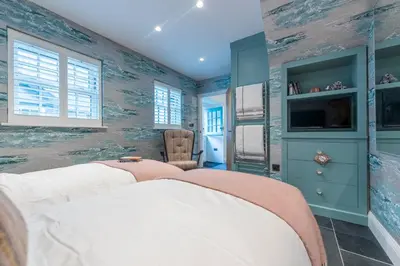 a bedroom with two beds and a tv at Iris 5 Star Gold Award Luxury Cottage in St Ives