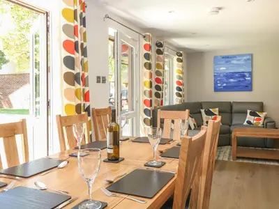 a dining room with a wooden table with wine glasses at 32 Trevithick in Hayle