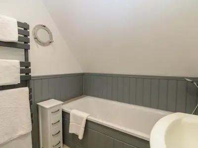 a bathroom with a bath tub and a sink at 32 Trevithick in Hayle
