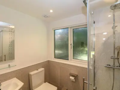 a bathroom with a toilet and a glass shower at 32 Trevithick in Hayle