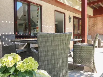 an outdoor patio with chairs and a table and flowers at 32 Trevithick in Hayle