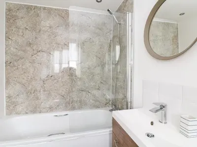 a bathroom with a white tub and a mirror at Pen Chy in Helston