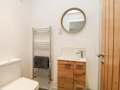 a bathroom with a toilet and a sink and a mirror at Pen Chy in Helston