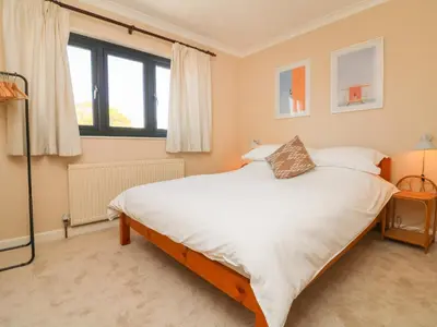 a bedroom with a large bed with white sheets at Auverne in Bude