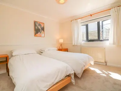 two beds in a bedroom with a window at Auverne in Bude
