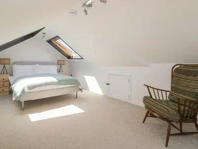 a bedroom with a bed and a chair at Auverne in Bude