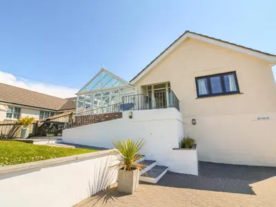 a white house with a staircase in front of it at Auverne in Bude