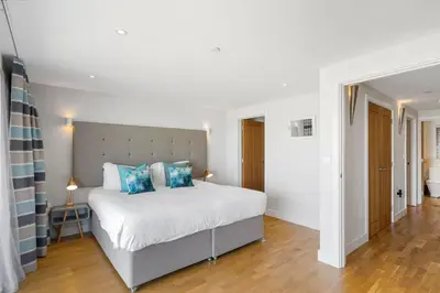 a bedroom with a large white bed with blue pillows at SeaEsta in Portreath