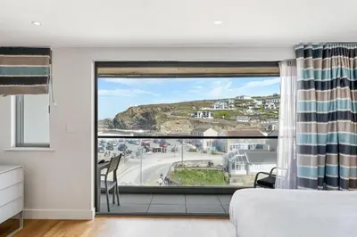 a bedroom with a bed and a large window at SeaEsta in Portreath