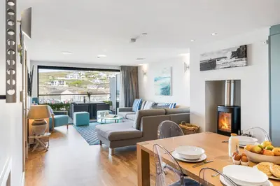 a living room with a couch and a table with a fireplace at SeaEsta in Portreath