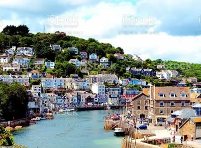 a view of a town with blue buildings and a river at On Season 4 of BBC 1s BEYOND PARADISE - Prospect House is TWO PRIVATE APARTMENTS in this 17th CENTURY COTTAGE - Apartment 2 has a KIDS CABIN BUNK ROOM - Book both apartments for ONE LARGE HOUSE with Connecting Door In Lobby - FREE PUBLIC PARKING OUTSIDE in Looe