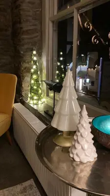 a table with two christmas trees in a room at On Season 4 of BBC 1s BEYOND PARADISE - Prospect House is TWO PRIVATE APARTMENTS in this 17th CENTURY COTTAGE - Apartment 2 has a KIDS CABIN BUNK ROOM - Book both apartments for ONE LARGE HOUSE with Connecting Door In Lobby - FREE PUBLIC PARKING OUTSIDE in Looe