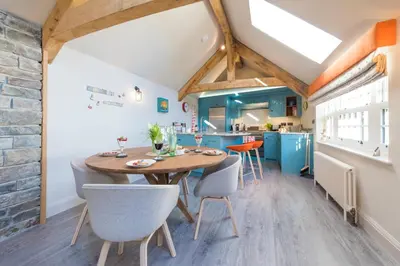 a kitchen and dining room with a wooden table and chairs at Wella 5 Star Gold Award Luxury Cottage in St Ives